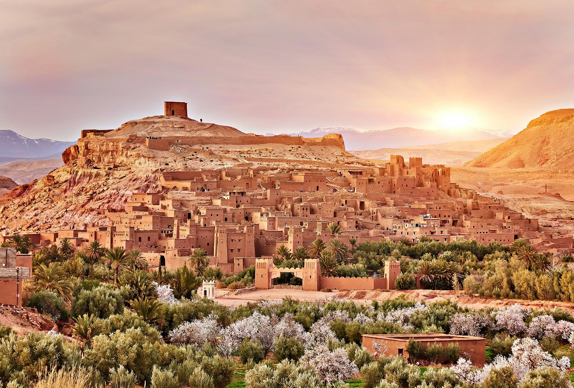 Sunrise over Ait Ben Haddou with blossoming orchards in the foreground